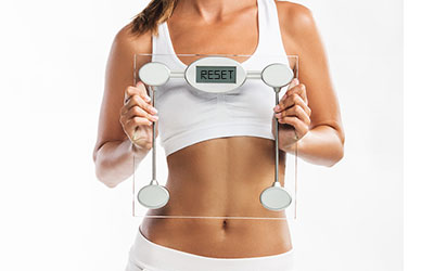 Fit Woman holding scale - Reset Therapy